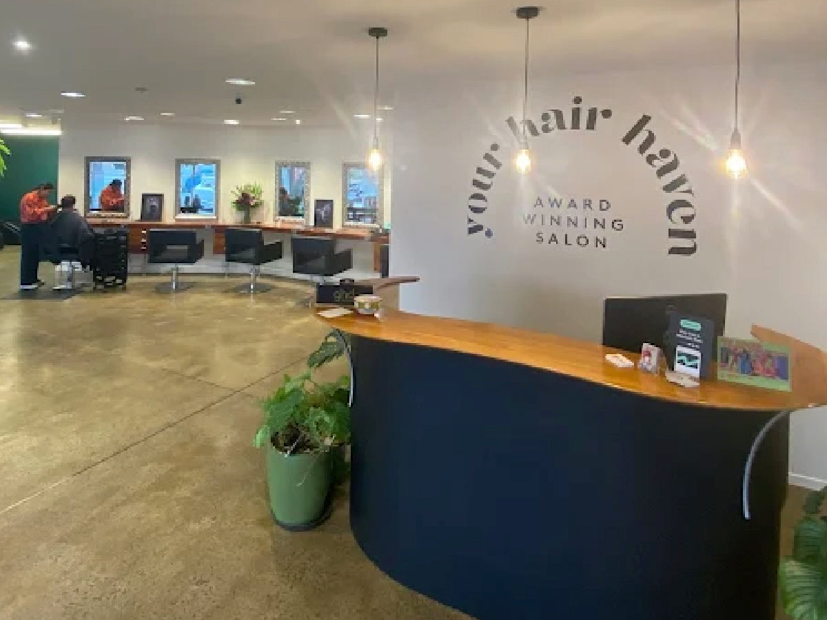 Salon interior with reception desk and 'Your Hair Haven' sign on the wall.